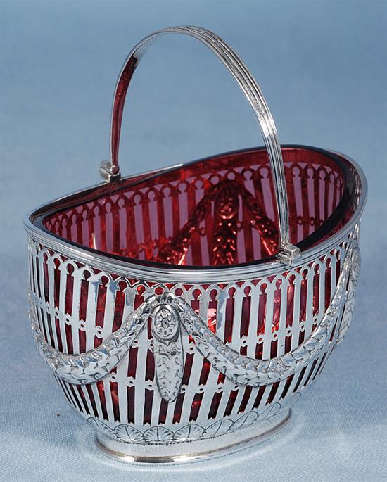 A Victorian silver swing handled sugar basket with cranberry glass liner, length 128mm, weight silver only 5.3oz/151grms